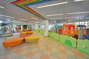 uma área recreativa para crianças com um tecto de arco-íris em Aparthotel Imperial em Bibione