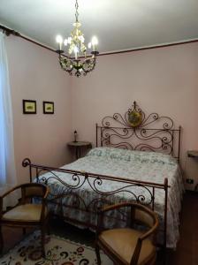 PreselleにあるAgriturismo La Carlettaのベッドルーム1室(ベッド1台、椅子2脚、シャンデリア付)
