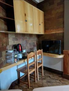 Simple Room in a Transient House في باغيو: مطبخ مع طاوله وكرسيين وموقد