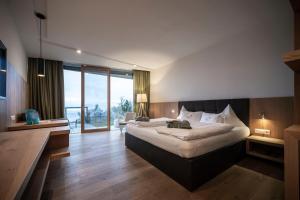 Un pat sau paturi într-o cameră la Hotel Belvedere - Fine Dining, Hideaway & SPA
