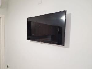 telewizor z płaskim ekranem wiszący na ścianie w obiekcie La Perla Mare Apartments w mieście Capo Vaticano