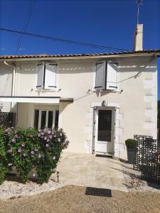 a white house with a door and flowers at la bouquetiere in Mazières-en-Gâtine +30 photos