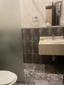 a bathroom with a sink and a toilet and a mirror at رغد الشاطئ للاجنحة الفندقية in Jeddah