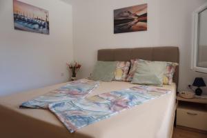 a bed with a comforter on it in a bedroom at Apartmani Skledar in Vodice