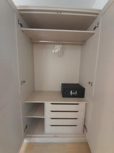 a walk in closet with a white cabinet and a black appliance at Townhouse Rustik Portoroz in Portorož