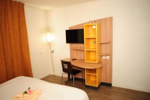 a hotel room with a desk and a bed at 5 minutes du Zénith - Studio Chic in Pantin