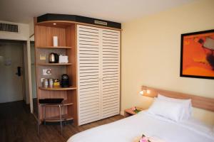 sypialnia z łóżkiem i półką na książki w obiekcie 5 minutes du Zénith - Studio Chic w mieście Pantin