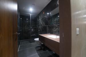 a bathroom with a sink and a shower and a toilet at HOTEL STATURE INN in Kevadia +35 photos