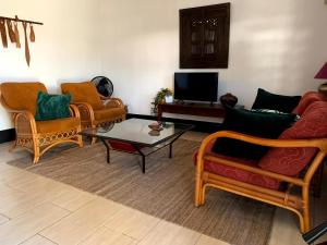 Sala de estar con 2 sofás y mesa de centro en Klein-kronenburg Bakkershuisje, en Paramaribo