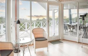 エーベルトフトにあるNice Home In Ebeltoft With House Sea Viewのテーブルと椅子、バルコニーが備わる客室です。