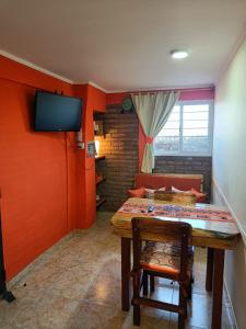 Habitación con mesa, TV y sofá. en Rayo Solar Depto Rama Caída en San Rafael