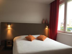 um quarto com uma cama com duas almofadas em Hôtel Bar le Globe em Saint Die