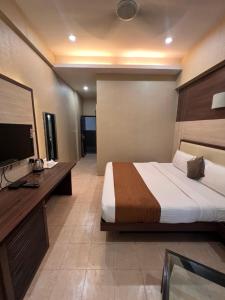 um quarto de hotel com uma cama e uma televisão em Hotel SB Castle em Kanpur