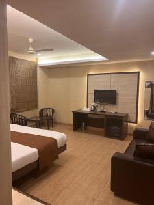 a hotel room with a bed and a flat screen tv at Hotel SB Castle in Kānpur