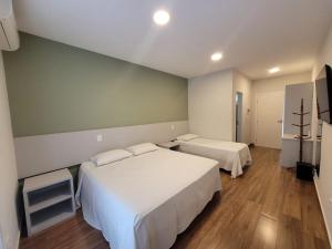 阿瓜斯迪林多亞的住宿－Pousada Thermas das Montanhas，一间酒店客房,设有两张床和电视