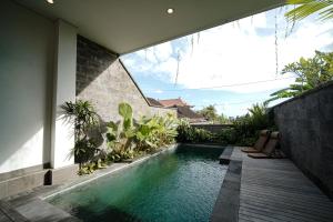 a swimming pool in the middle of a house at Wakasuta House in Ubud