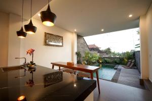 a living room with a table and a view of a pool at Wakasuta House in Ubud