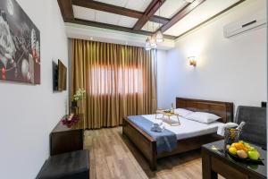 um quarto com uma cama, uma mesa e uma janela em Hotel House em Rishon LeZion