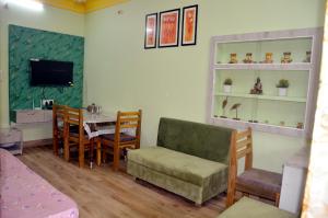 a living room with a table and chairs and a tv at Pinakin Homestay Near mahakal temple in Ujjain