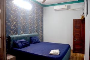 een slaapkamer met een blauw bed met een blauwe deken bij Pinakin Homestay in Ujjain