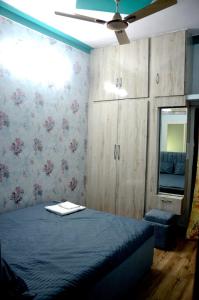 een slaapkamer met een bed en een plafondventilator bij Pinakin Homestay in Ujjain