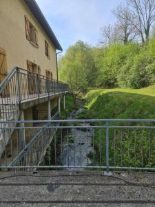 a walkway next to a building with a river next to it at Au Pilandre in Arinthod