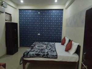 a bedroom with a bed with a blue wall at Spot ON HOME 81265 Hotel Sitasmriti in Phāphāmau