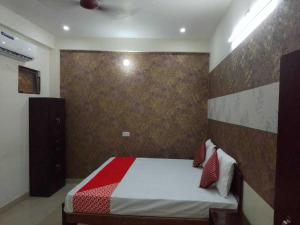 a bedroom with a bed with a red and white blanket at Spot ON HOME 81265 Hotel Sitasmriti in Phāphāmau
