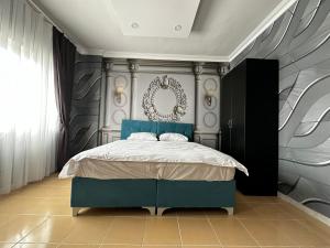 een slaapkamer met een blauw bed en een spiegel bij NUS GRAND HOTEL 