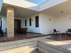 een patio met stoelen en tafels in een huis bij Villa Capri Holiday Home in Campofelice di Roccella