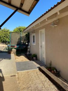 una casa con un porche con una escalera al lado en דירת חדר נעימה במיקום פסטורלי, en Kiryat Shemona