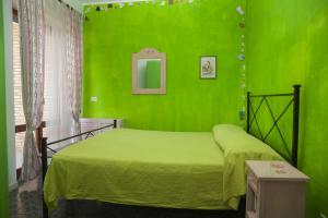 テッラチーナにあるHoliday Home Elenaの緑の壁のベッド付きの緑のベッドルーム1室