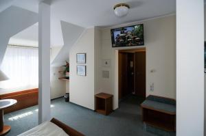 una habitación de hotel con TV en la pared en Alfa Apartment Hotel, en Neu Isenburg