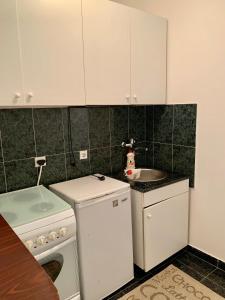 eine kleine Küche mit weißen Schränken und einem Waschbecken in der Unterkunft Sanja apartment in Prčanj