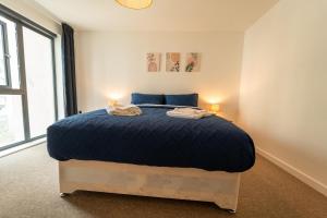 a bedroom with a large bed with two lamps at Spacious Apartment in Woking Town Centre in Woking