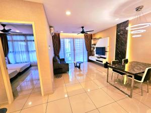 un soggiorno con tavolo da pranzo e una camera da letto di Atlantis Residence Waterpark Executive Suites Melaka By GGM a Malacca