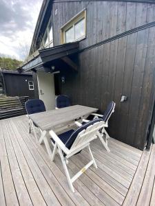 una mesa de madera y sillas en una terraza en Hytteleilighet på Strandafjellet, en Stranda