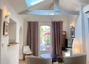 ein Wohnzimmer mit einem Tisch, Stühlen und einem Fenster in der Unterkunft Studio indépendant, front de mer et plage à 200m in Antibes