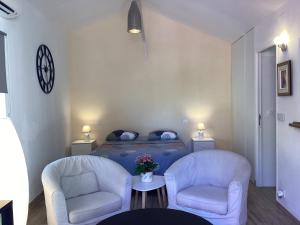 - un salon avec deux chaises et un lit dans l'établissement Studio indépendant, front de mer et plage à 200m, à Antibes
