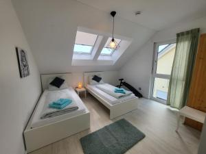 1 dormitorio con 2 camas y ventana en Ferienwohnung Zartgrün Blumberg, en Blumberg