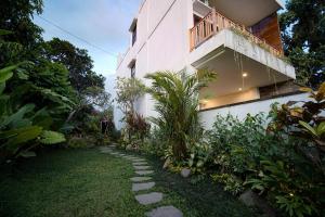 a walkway in front of a building with a balcony at Wakasuta House in Ubud