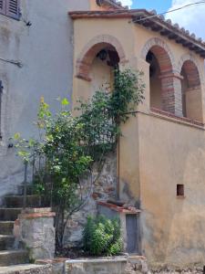 - un bâtiment ancien avec 2 fenêtres cintrées et des escaliers dans l'établissement Nonna Zaira, à Seggiano