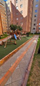 a park with swings and a playground with buildings at Hermoso y lujoso apartamento de descanso in Quito
