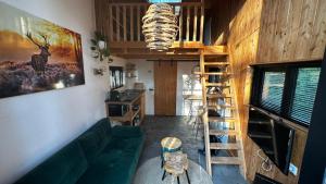 - un salon avec un canapé vert et un mur en bois dans l'établissement TinyStay Veluwe, à Otterlo