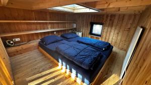 - une vue de tête sur un lit dans une cabane en rondins dans l'établissement TinyStay Veluwe, à Otterlo