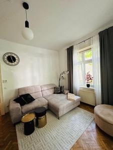 ein Wohnzimmer mit einem Sofa und einem Fenster in der Unterkunft Apartment 5 min Schönbrunn Gloriette, Direct to City Center, Free Parking in Wien