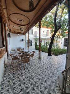 a patio with tables and chairs on a tiled floor at Chorsu Inn in Tashkent