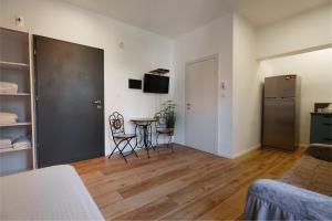 a living room with a table and a refrigerator at Zimmer Garden in Haifa