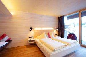 a bedroom with a white bed and a large window at n Apartments Hotel in Schoppernau +61 photos