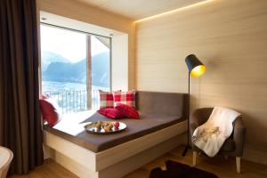 a bed in a room with a window and a plate of food at n Apartments Hotel in Schoppernau